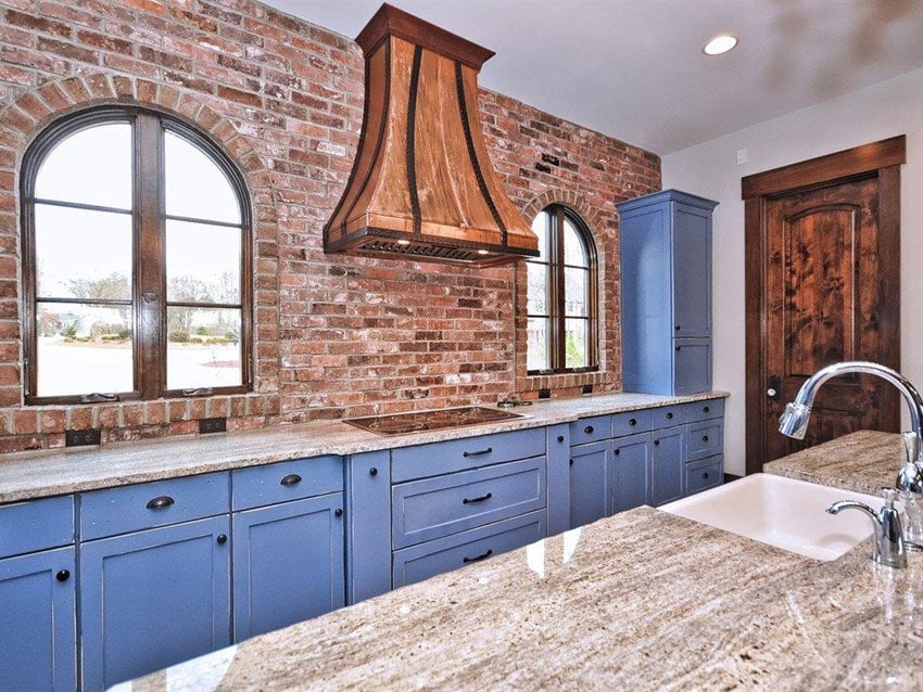 Traditional blue cabinet kitchen against brick wall