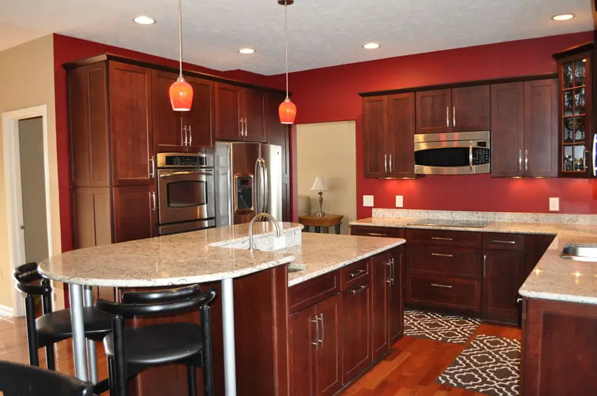 Kitchen with red walls, pendant lights and cream countertop