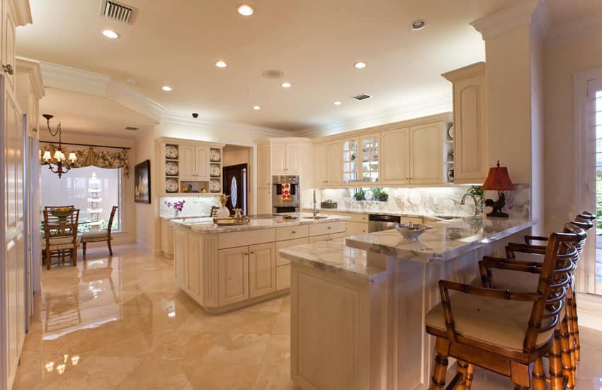 Traditional kitchen with stone floors and off white cabinetry