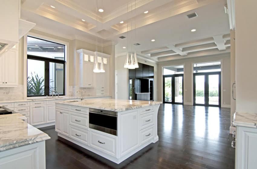 Traditional open layout kitchen with white cabinets and marble counters