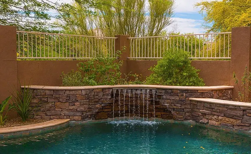 Water feature at pool with stacked stone wall