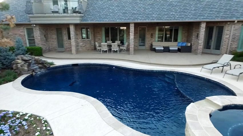 Backyard swimming pool with hot tub brick house