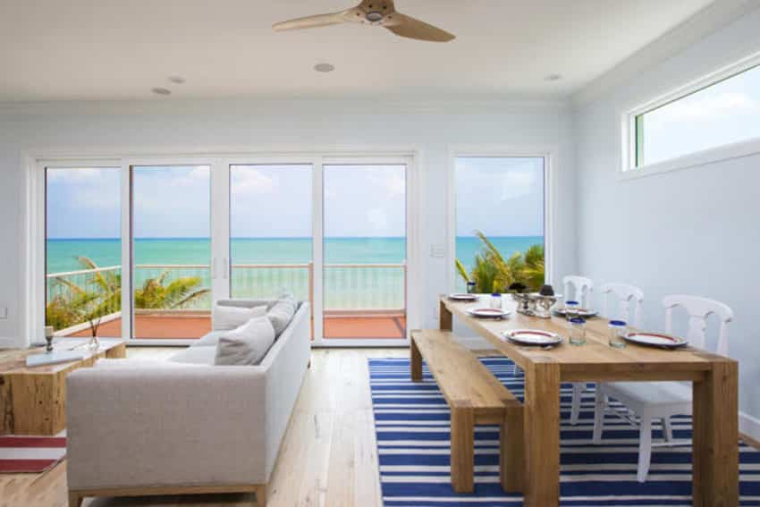 Beach house with wooden dining set, white walls with balcony view
