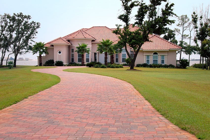 Brick driveway to home with waterfront views