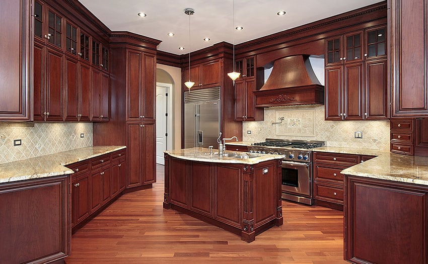 cherry wood kitchen with light granite counter center island and tile backsplash