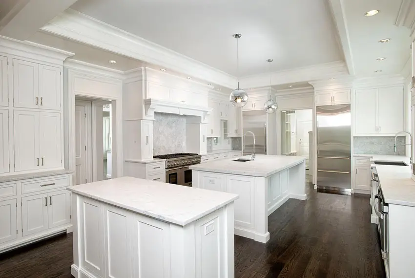Contemporary white kitchen with two islands and marble countertops