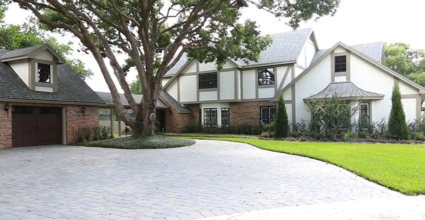 Front of Tudor style home with brick circular driveway