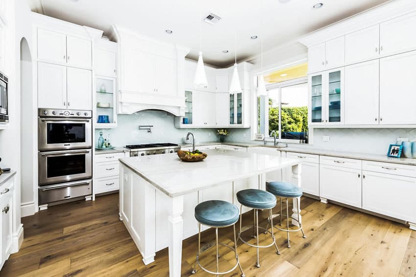 Kitchen with white cabinets carrara marble counter and mini pendant lights