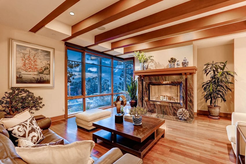 Room with faux wood beams, ottoman, fireplace and armchair