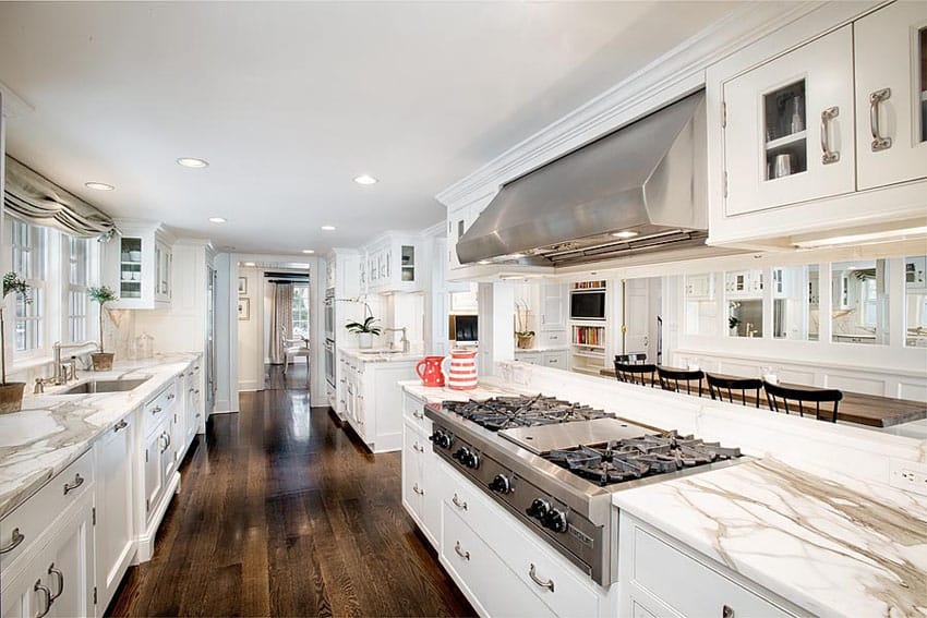 Luxury galley kitchen with white cabinets marble counters and mocha oak hardwood floors