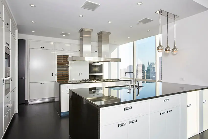 Kitchen with black island, pendant lights, and cabinets