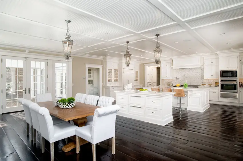 Open concept kitchen with white cabinets and corian countertop with dark wood floor
