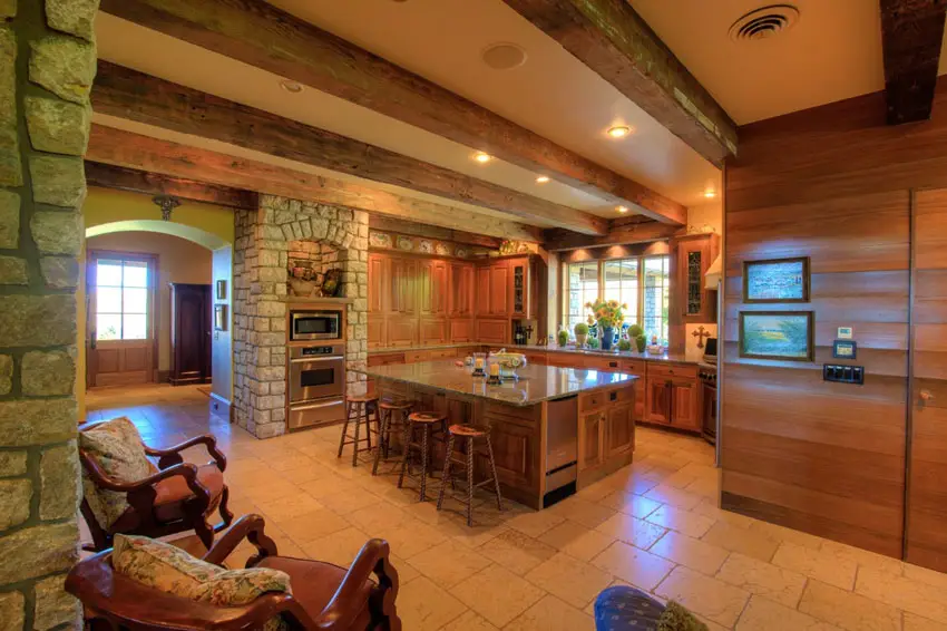 Kitchen with exposed beams, stone walls and tile flooring