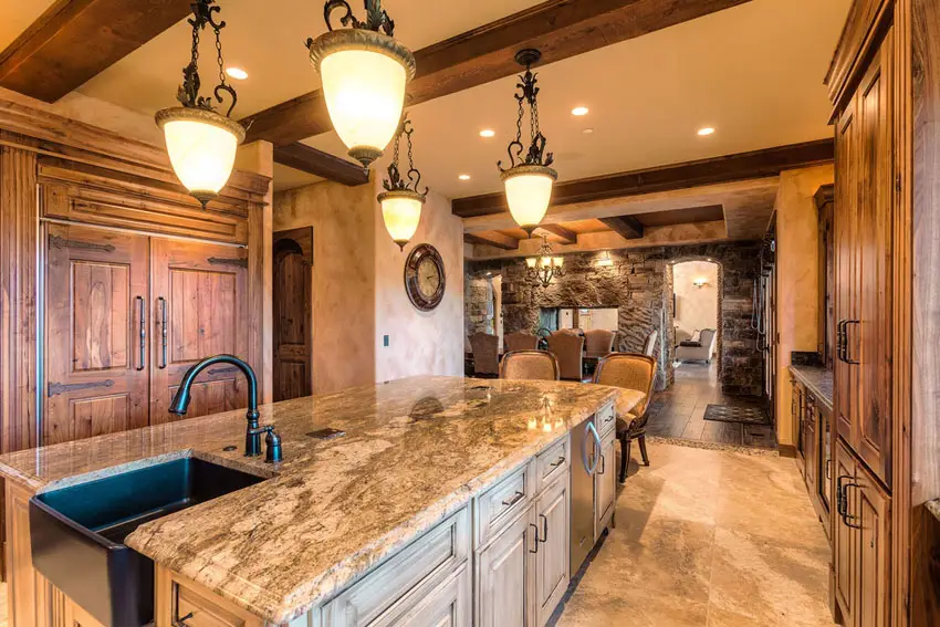 Kitchen with exposed wood trusses and granite island opening to dining room