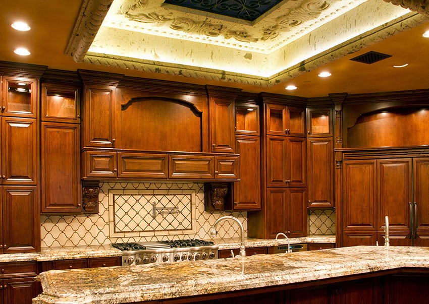 Paneled cabinets with brass knobs and coffer ceiling with cove lighting