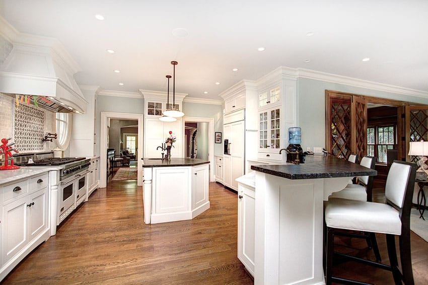 Traditional kitchen with black soapstone counter island, white cabinets and ash hardwood flooring