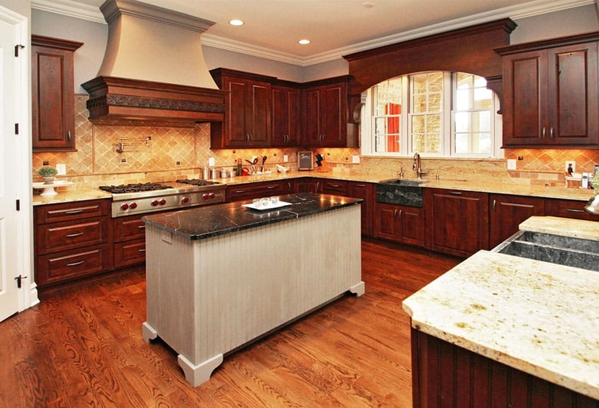 Kitchen with hardwood plank flooring, narrow island and slate tiles for the backsplash