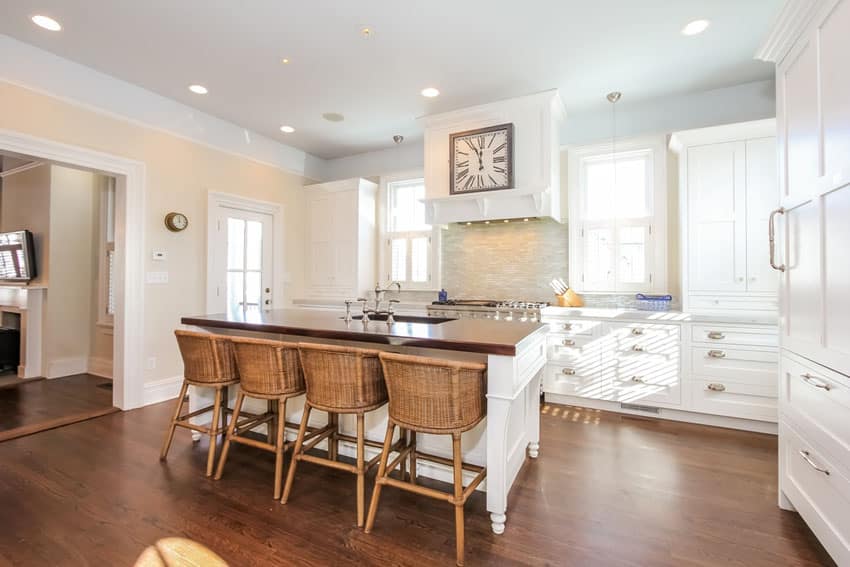 Kitchen with white-colored cabinets and butcher block island