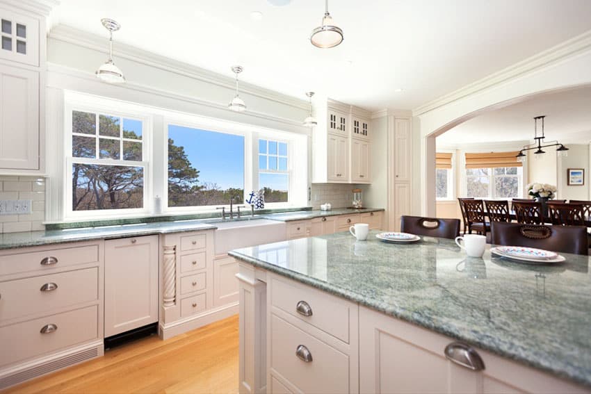 Kitchen with white-painted cabinets and tropical green counters