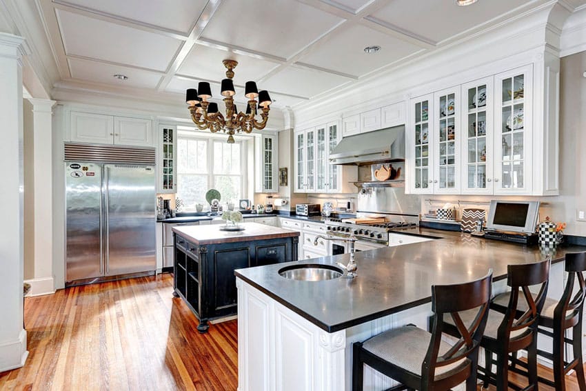 Traditional kitchen with white glass faced cabinets and black quartz counter tops
