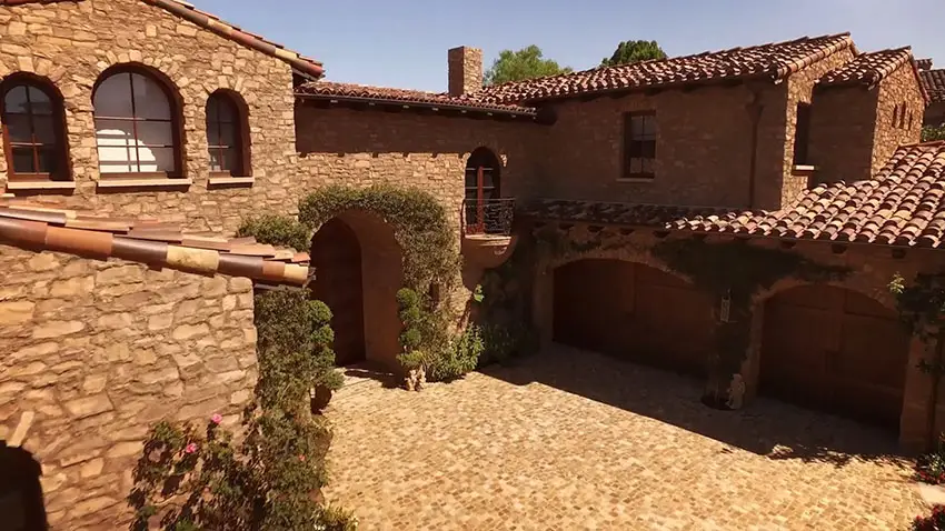 Tuscan style home's front entrance and triple car garage