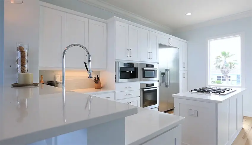 White cabinet kitchen with quartz counters in beach house