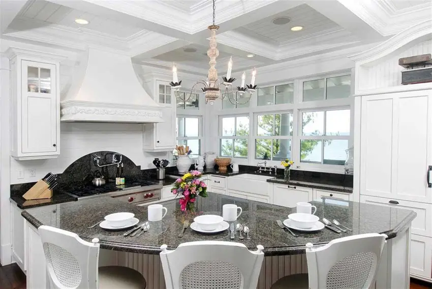 White country style kitchen with chandelier and curved dining island