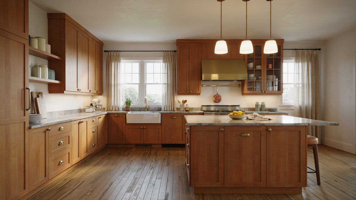 Warm cherry shaker cabinets with brass hood and gray marble island counter