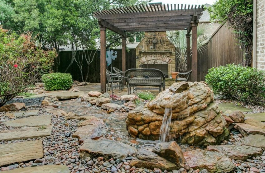 Backyard rock garden with small water feature and pergola