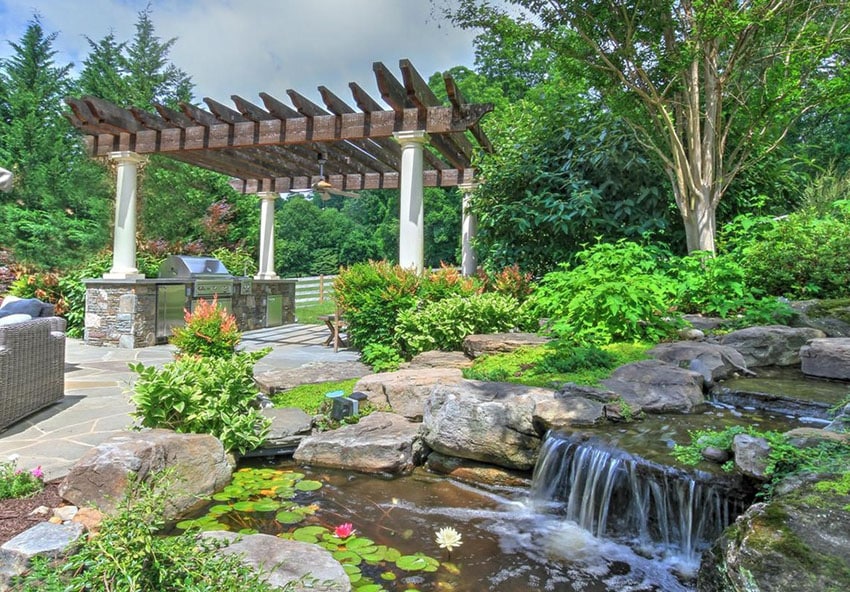 Backyard waterfall and stream next to pergola