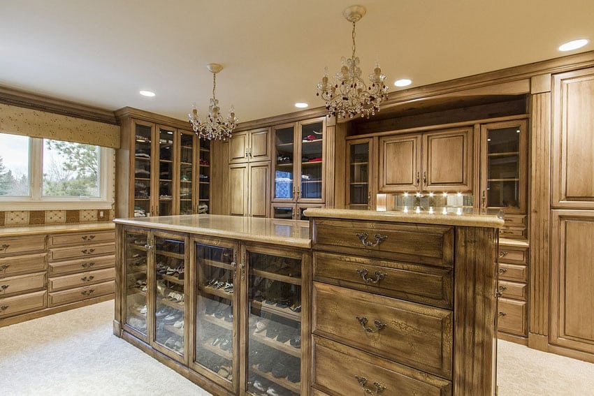 Big luxury walnut closet with 2 chandeliers and center island with shoe rack dresser