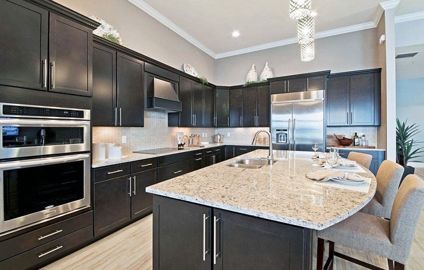 Kitchen with black European cabinets, gray colored walls and light hued granite countertops