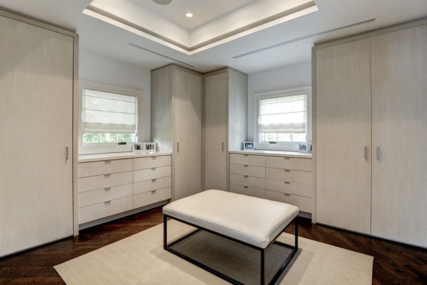 White maple laminated cabinets, maple floor laminates and rectangular ottoman
