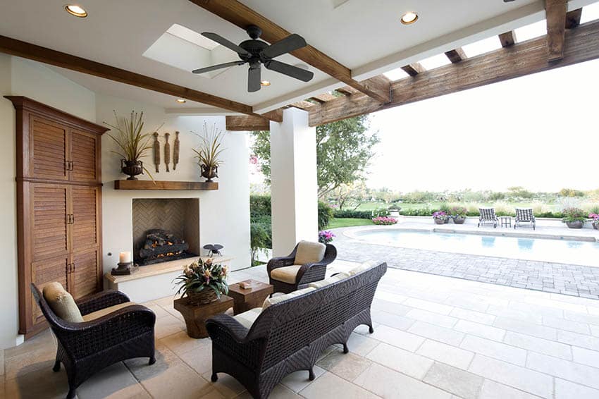Covered patio with fireplace ceiling fan and swimming pool