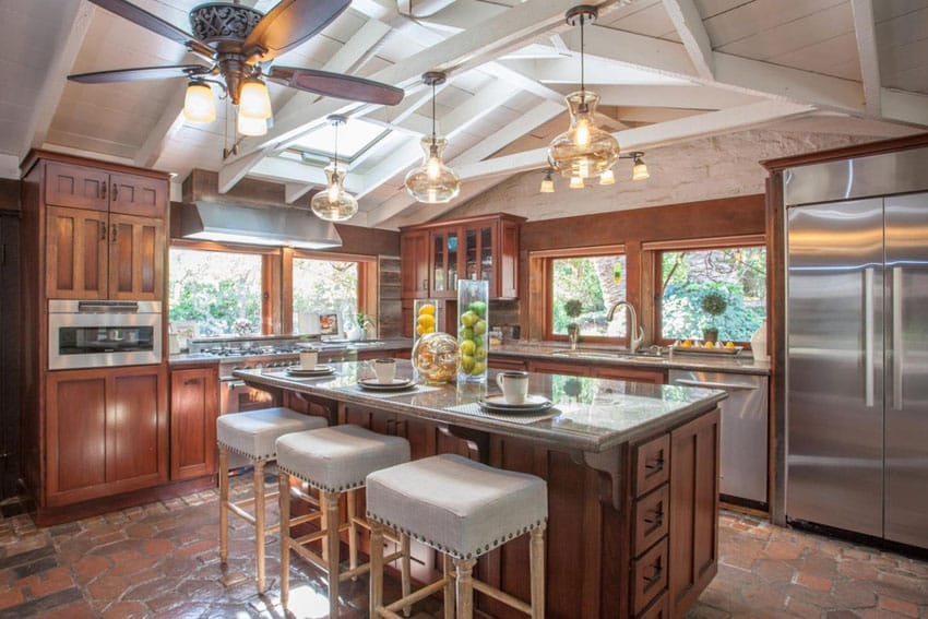 Craftsman kitchen with adobe floor tile and vaulted ceiling