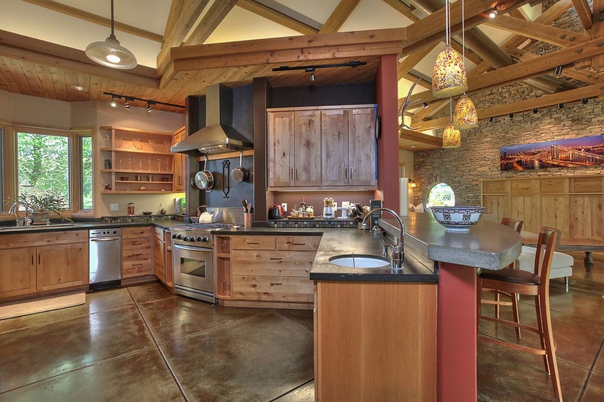 Craftsman kitchen with impala black granite peninsula and concrete floors