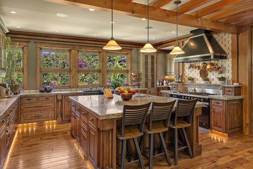 Kitchen with square island with drawers, wood slat chaurs and gray counters