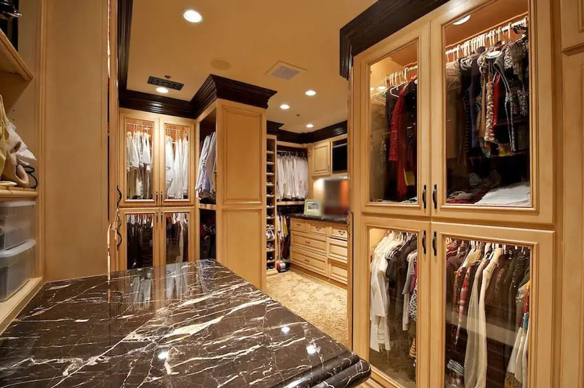 Maple wood closet cabinets, dark wood cornices and black marble top