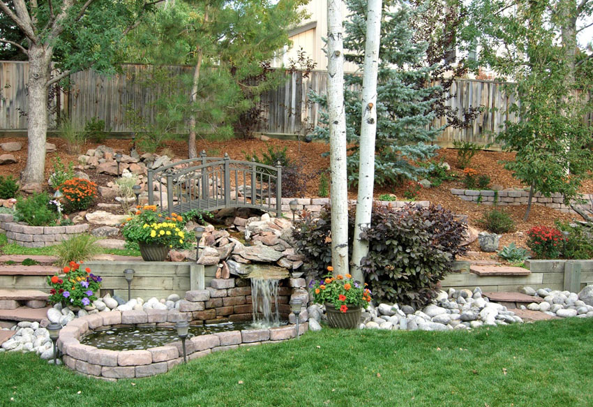 Garden path with waterfall and pond surrounded by brick pavers