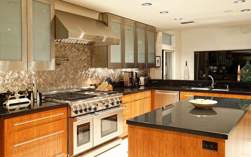 Kitchen with swirled stainless steel backsplash with alder wood under sink cabinets