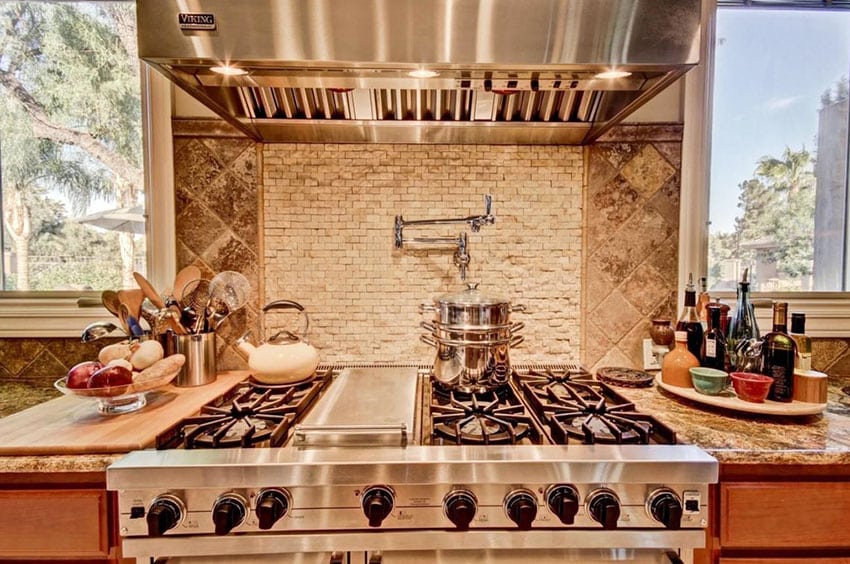 Kitchen with tumbled travertine tiles, steel hood and oven