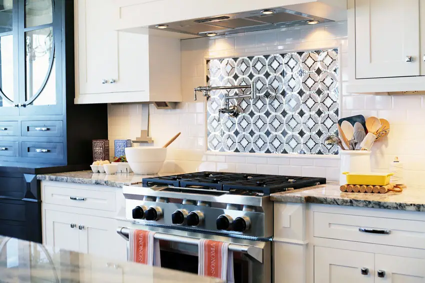 Kitchen with black and white inset tiles and range cook top