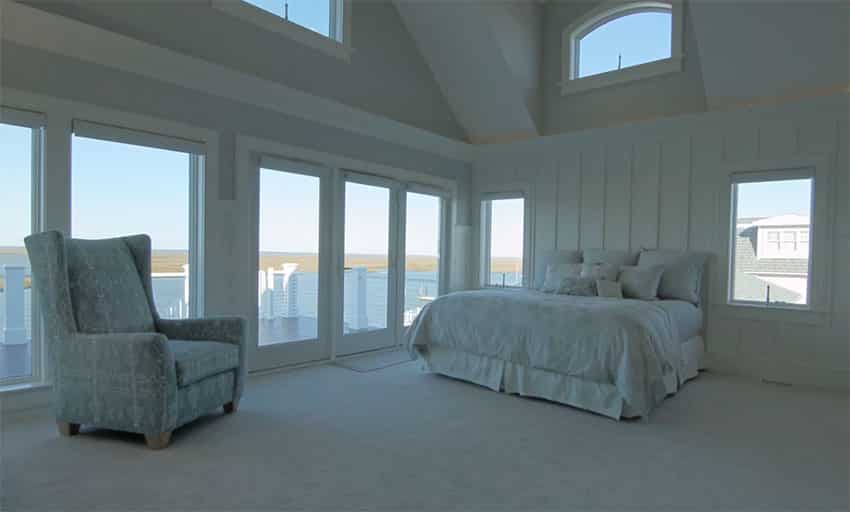 Large master bedroom with bay views balcony and high ceilings