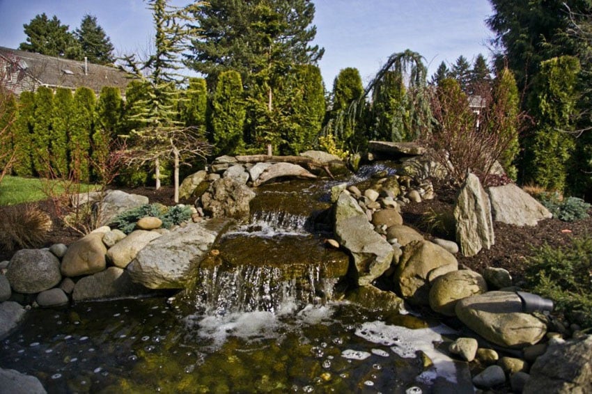 Large natural looking stone waterfall in backyard