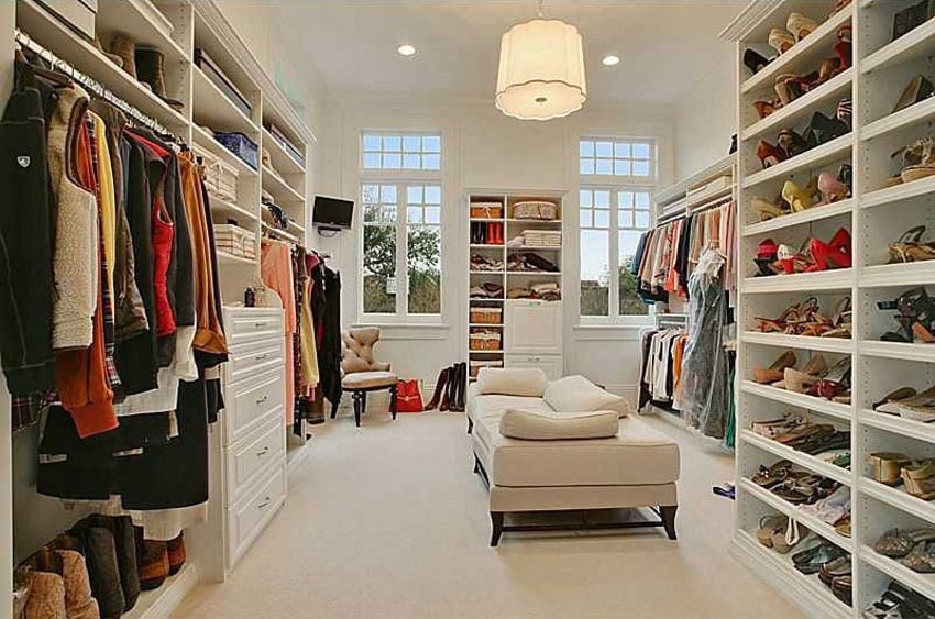 Large walk in closet with white theme and daybed