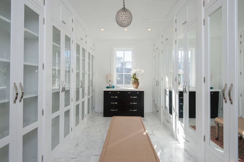 Luxurious walk in closet with white mirror cabinets marble floor and pendant light