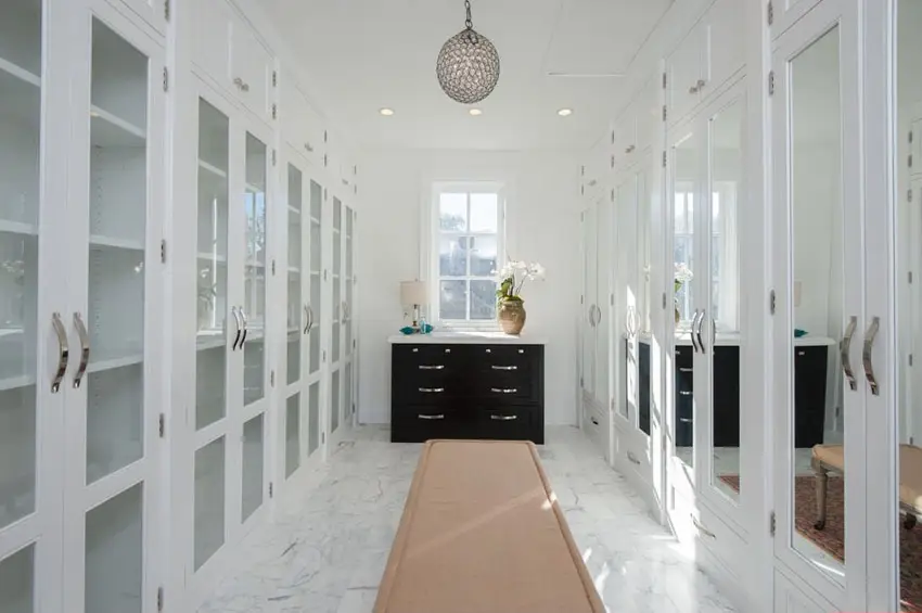Closet with white mirrored cabinets, white floor and pendant light