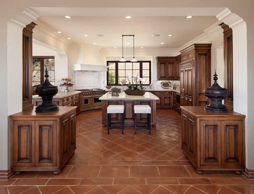 Luxury kitchen with center island molding and terra cotta floors