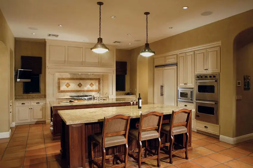 Kitchen with double counters, three chairs and white cabinets