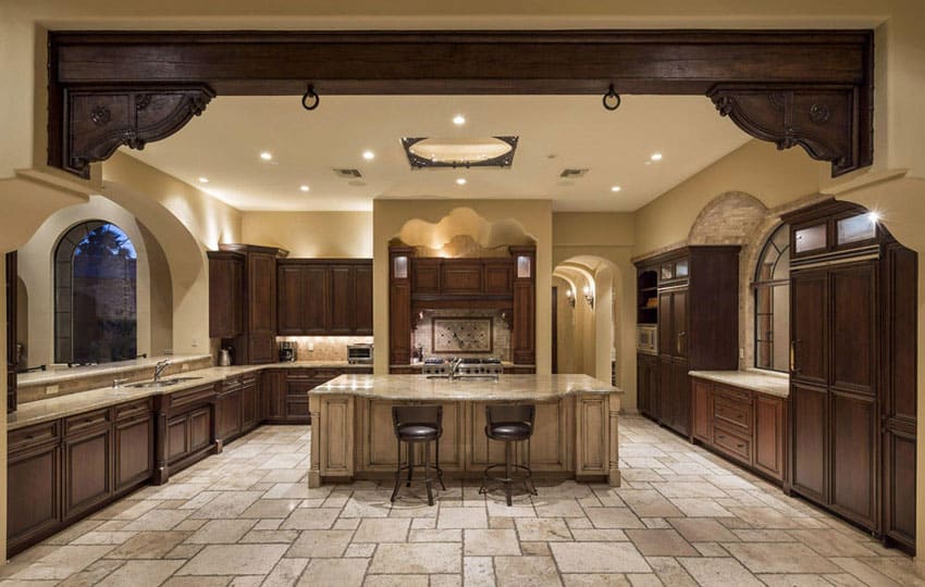 mediterranean style kitchen with dark wood cabinets and travertine flooring